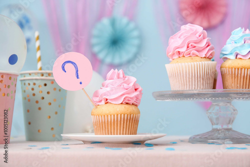 Delicious cupcakes with cups and decorations on table against blue background. Gender reveal party concept