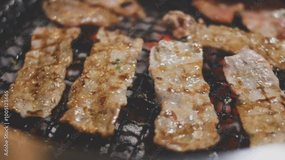 Grilled meat on a charcoal grill pan at Korean BBQ restaurant. Grilled meat on a charcoal grill pan at Korean BBQ restaurant.