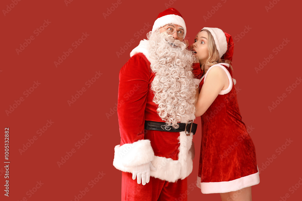 Beautiful young woman telling secret to Santa Claus on red background Beautiful young woman telling secret to Santa Claus on red background