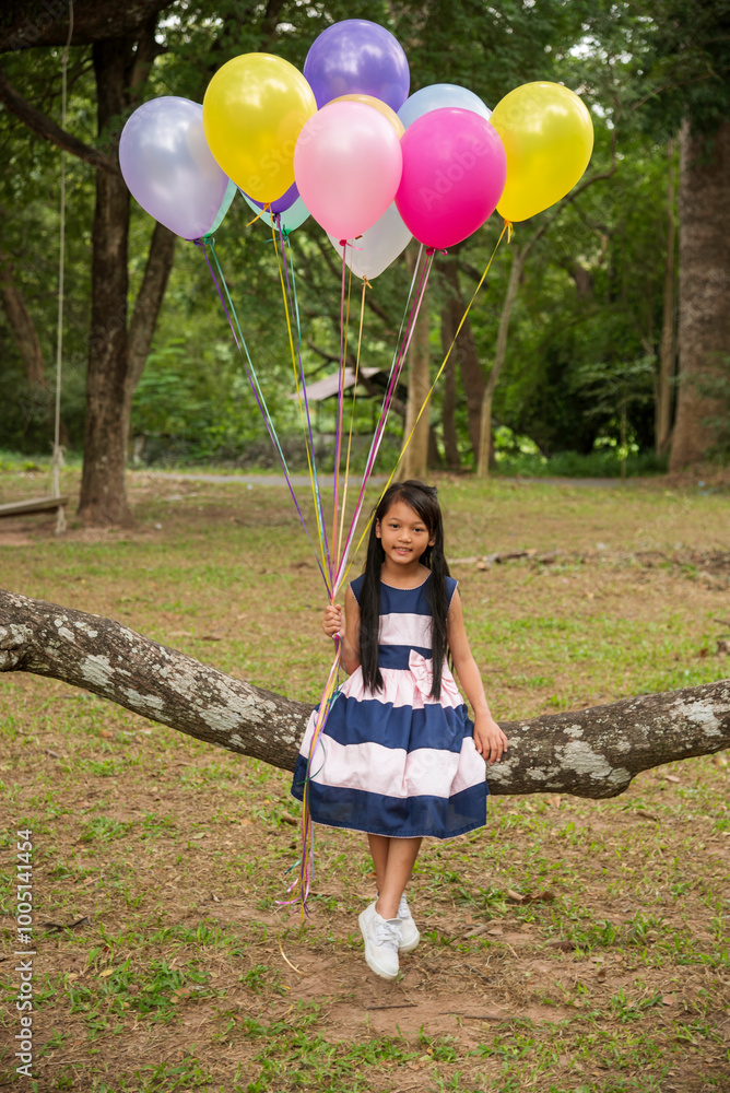 Φωτογραφία Vertical Cheerful beauty woman holding balloons relax sitting under big tree in green park with happiness