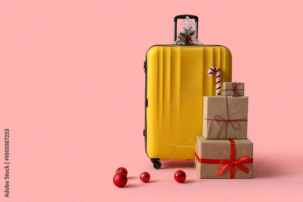 Suitcase with presents and Christmas balls on pink background Suitcase with presents and Christmas balls on pink background