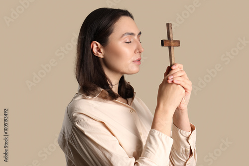 Young woman praying with cr...