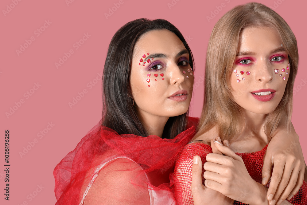 Young women with beautiful makeup on pink background. Valentine's Day celebration Young women with beautiful makeup on pink background. Valentine's Day celebration