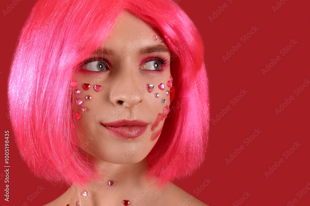 Young woman in pink wig with beautiful makeup and kiss mark on red background. Valentine's Day celebration Young woman in pink wig with beautiful makeup and kiss mark on red background. Valentine's Day celebration