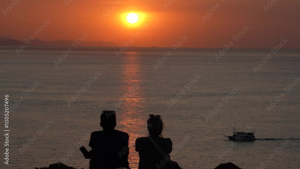 A couple watching the sunset in the north of Labuan Bajo, A couple enjoying the sunset from a hill in the north of Labuan Bajo A couple watching the sunset in the north of Labuan Bajo, A couple enjoying the sunset from a hill in the north of Labuan Bajo