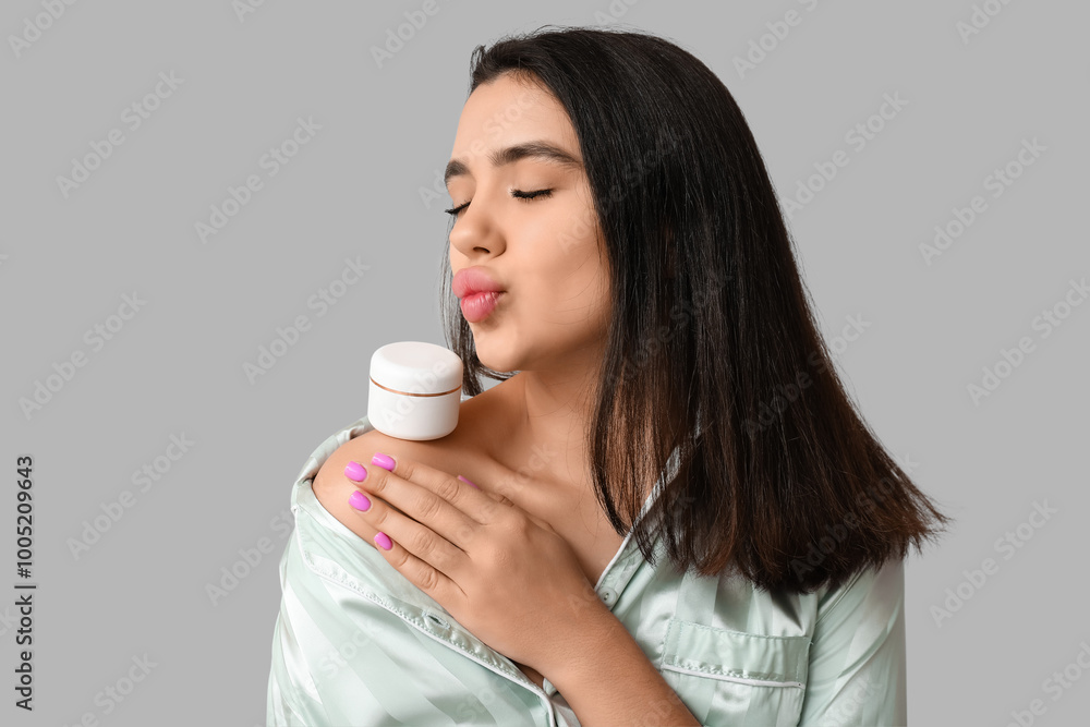 Beautiful young woman with jar of cosmetic product on grey background Beautiful young woman with jar of cosmetic product on grey background