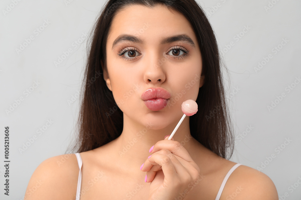 Young woman with lollipop on grey background, closeup Young woman with lollipop on grey background, closeup
