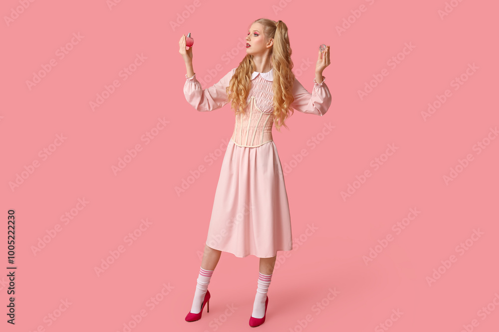 Beautiful young woman dressed as doll with bottle of perfume on pink background Beautiful young woman dressed as doll with bottle of perfume on pink background