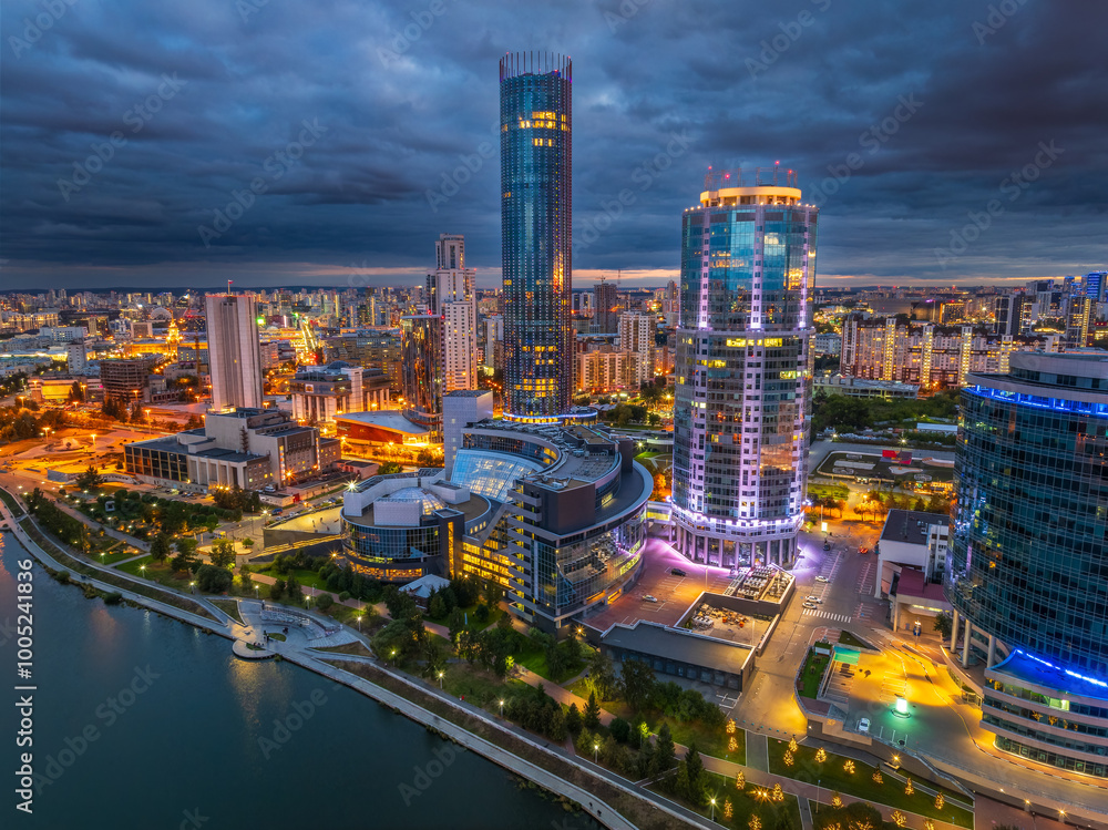 Fototapeta premium Yekaterinburg city and pond aerial panoramic view at summer or early autumn night. Night city in the early autumn or summer.