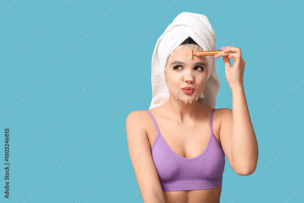 Beautiful young woman with sheet facial mask using massage roller on color background Beautiful young woman with sheet facial mask using massage roller on color background