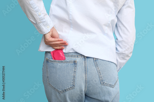 Foto Woman with condom in pocket on color background