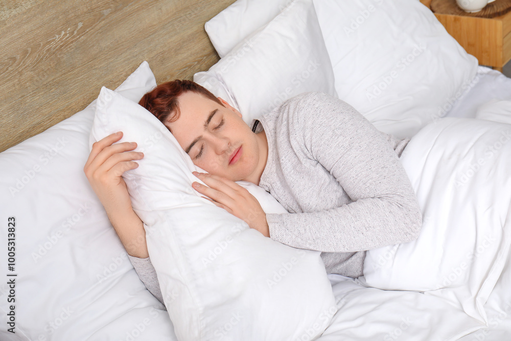 Morning of handsome young man in stylish pajamas sleeping on bed at home Morning of handsome young man in stylish pajamas sleeping on bed at home