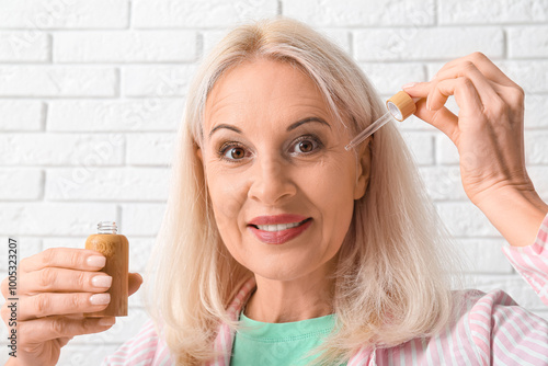 Mature woman with bottle of...