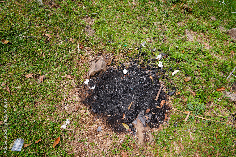 top view of burning residue isolated on grass, black grass and charcoal on green grass. top view of burning residue isolated on grass, black grass and charcoal on green grass.