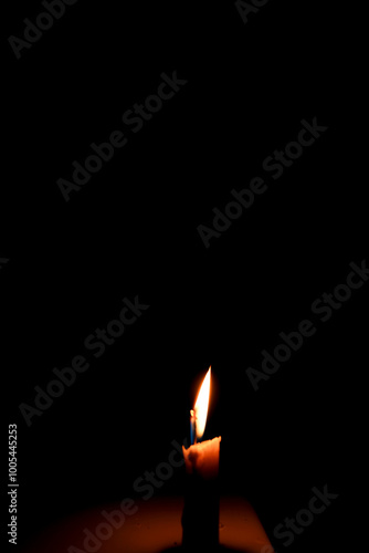 fire on white candle isolated on darkness with advertising empty space.