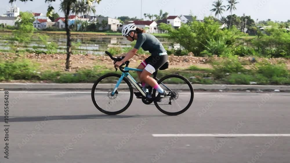 Women cyclist pedals energetically on nature. Women cyclist pedals energetically on nature.