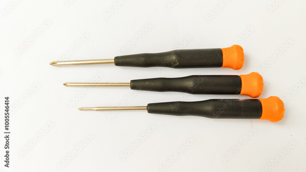 Set of red-orange-blue screwdrivers isolated on white background. Builder's and electrician's tools. Equipment. Set of steel screwdriver bits with red and black plastic handles. Set of red-orange-blue screwdrivers isolated on white background. Builder's and electrician's tools. Equipment. Set of steel screwdriver bits with red and black plastic handles.
