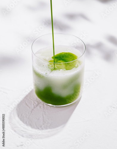 Barista pouring matcha latte in glass on white background