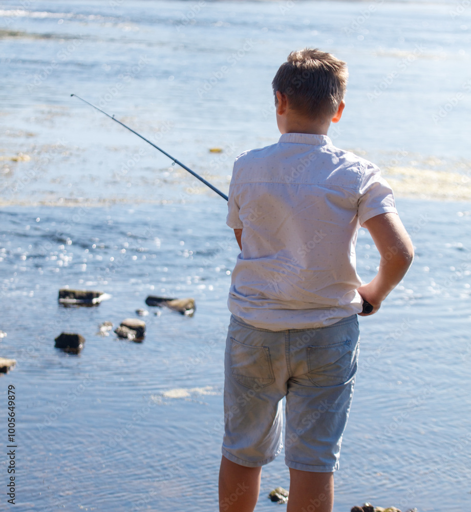 A young boy is fishing in a body of water A young boy is fishing in a body of water