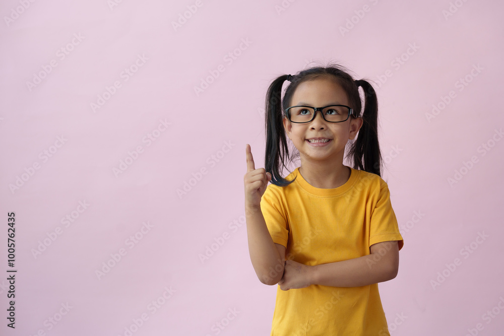 Portrait of a stylish little girl with fingers pointing up Little boy wearing glasses has an idea creative concept Child on pink background with copy space success bright ideas. Portrait of a stylish little girl with fingers pointing up Little boy wearing glasses has an idea creative concept Child on pink background with copy space success bright ideas.
