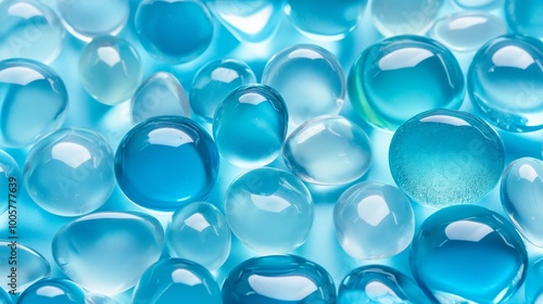 A collection of blue glass beads on a blue background. The beads are all different sizes and shapes, creating a visually interesting and dynamic composition photo