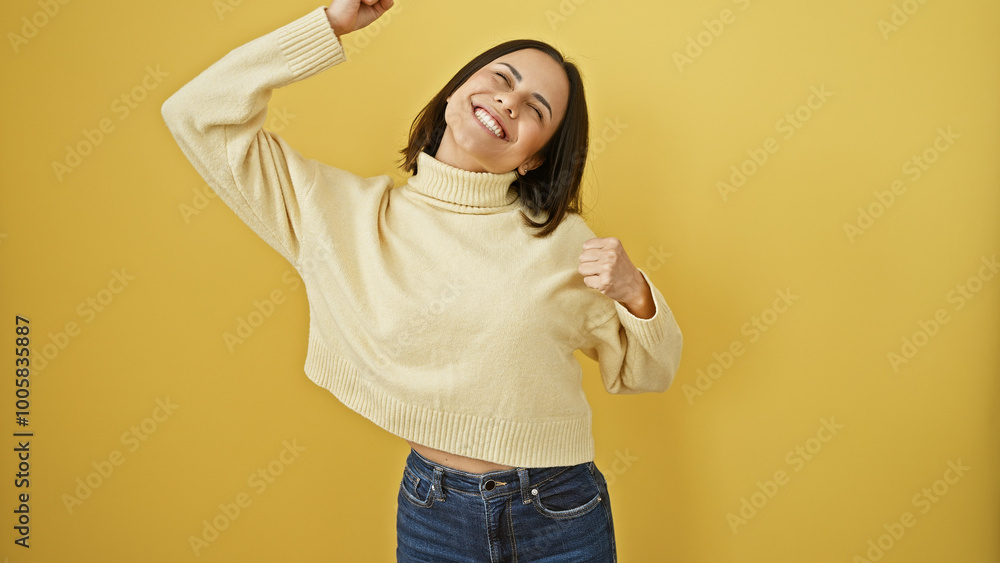 Portrait of a joyful young hispanic woman in a cream sweater posing against a yellow background. Portrait of a joyful young hispanic woman in a cream sweater posing against a yellow background.
