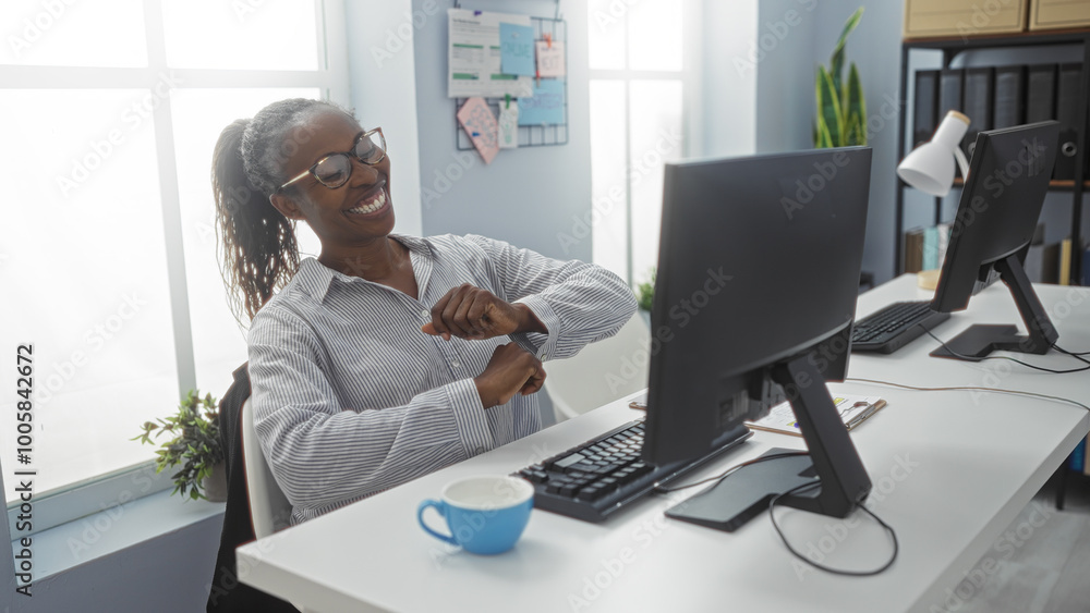 Young, african, woman, dancing, happily, while, looking, at, computer, screen, in, office Young, african, woman, dancing, happily, while, looking, at, computer, screen, in, office