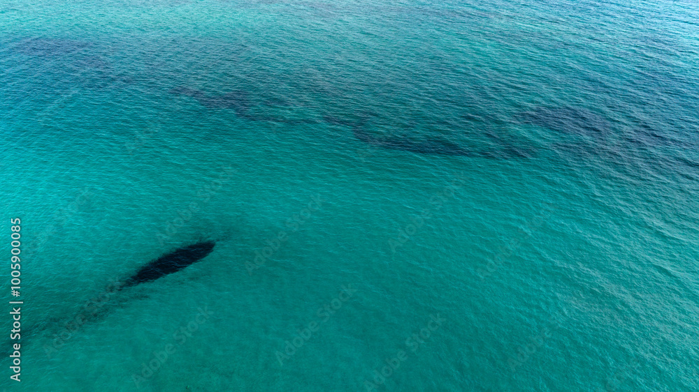 Fototapeta premium Aerial view of the sea surface with Caribbean colors of San Pietro in Bevagna in Puglia, Italy. Ideal for backgrounds, textures and patterns.