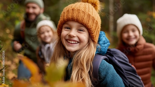 Happy family hiking in autumn forest, smiling girl in focus wearing warm clothing, enjoying nature and outdoor adventure together.