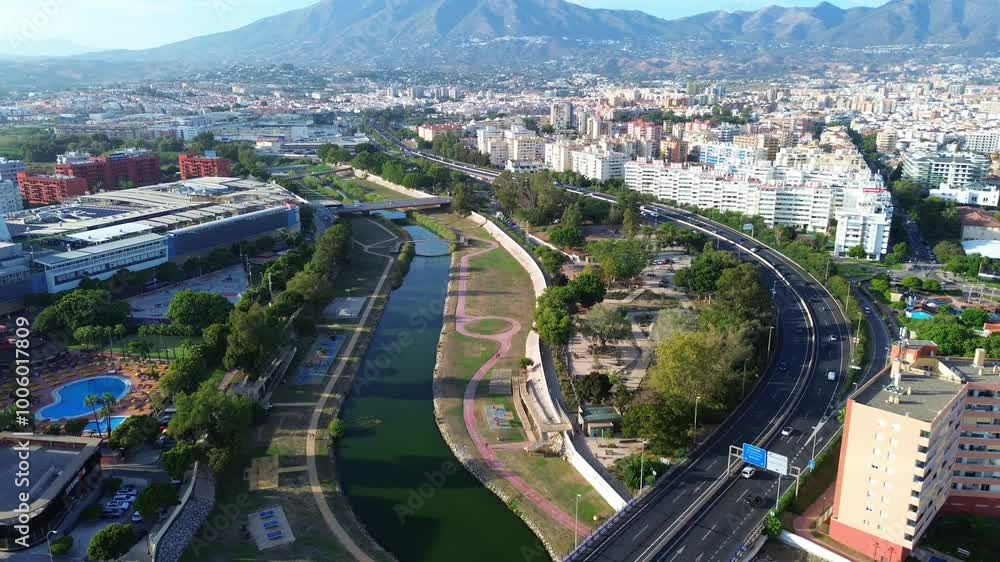 Aerial panoramic view of Fuengirola river, bridge, highway, residential sector, green park. Mountains in the background. Drone view. Aerial panoramic view of Fuengirola river, bridge, highway, residential sector, green park. Mountains in the background. Drone view.