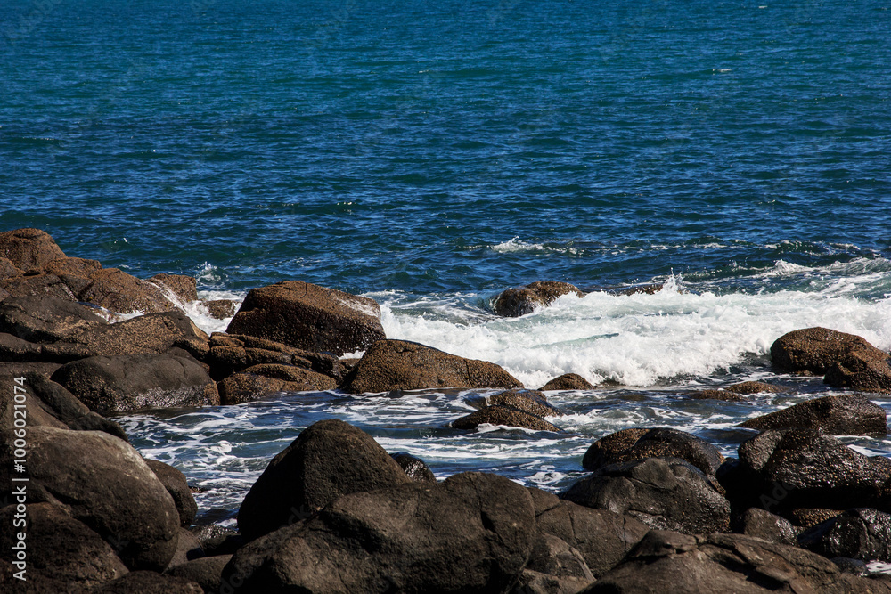 Large waves crash into coastal rocks. Dramatic sea shore background. Raglan, New Zealand Large waves crash into coastal rocks. Dramatic sea shore background. Raglan, New Zealand