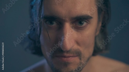 young handsome man without outerwear with long hair, brunette extra close up, large expressive eyes, long eyelashes, looks into the frame to the side, straightens his hair, slow motion photo