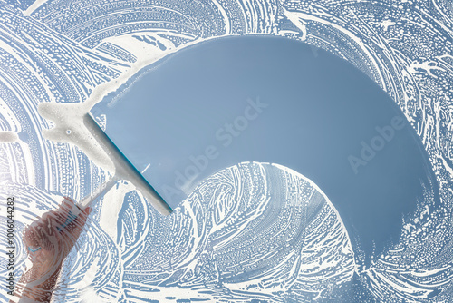 Window cleaner using a squeegee to wash and clean a window