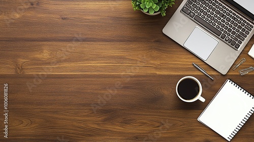 An overhead flat lay shot of a modern workspace setup on a rustic wooden desk.