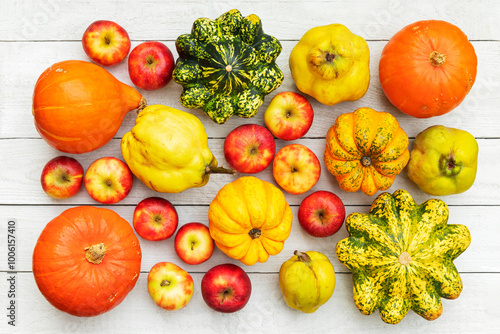 An assortment of apples, quince, and pumpkins on a wooden background photo