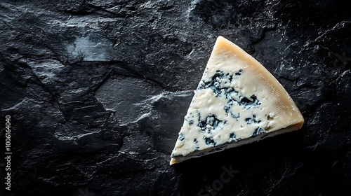 Close-up of a Roquefort cheese triangle with creamy texture, softly lit on a charcoal black surface. Gentle spotlight from above, visible blue veins, high contrast, minimalist composition,