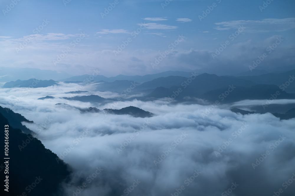 A breathtaking panoramic view of a sea of clouds below a crescent moon and a starry night sky. The silhouette of distant mountains adds depth and drama to this serene landscape. Xindian, Taiwan. A breathtaking panoramic view of a sea of clouds below a crescent moon and a starry night sky. The silhouette of distant mountains adds depth and drama to this serene landscape. Xindian, Taiwan.