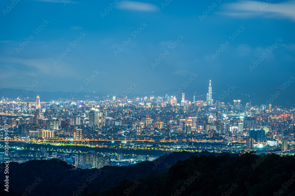 Fototapeta premium A breathtaking panoramic view of a bustling city at sunset. Soft, fluffy clouds drift across the sky, casting a warm glow over the urban landscape. Captured in Dading Mountain, Shulin, Taiwan.