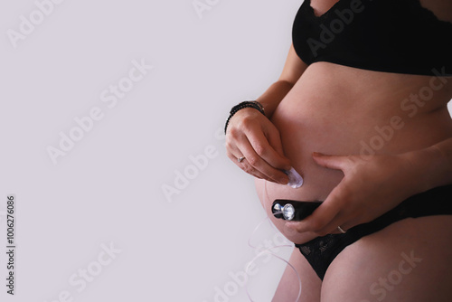 Pregnant woman removing infusion set from belly while holding insulin pump