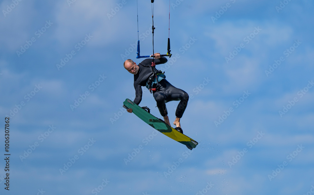 Adult man kitesurfing under blue skies in Falsterbo, Sweden Adult man kitesurfing under blue skies in Falsterbo, Sweden