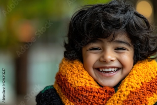 joyful child in warm knitted scarf with a bright smile