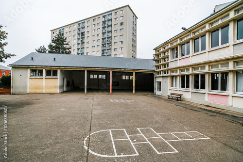 ORLEANS, FRANCE: empty primary school courtyard, with hopscotch game and tall apartment building, sad cloudy sky