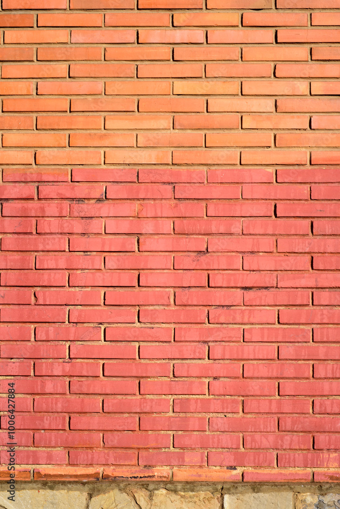 Obraz premium Pared de ladrillo pintado de rojo en exterior soleado