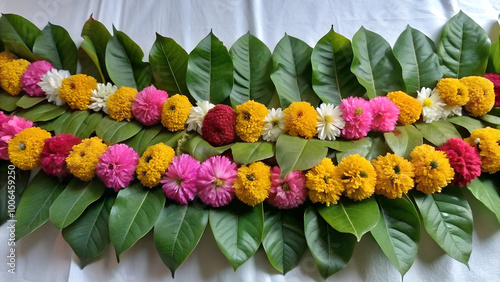 Indian flower garland of mango leaves and marigold flowers. Ugadi diwali ganesha festival poojas weddings holiday ornate decoration on the table mango leaf garland. photo