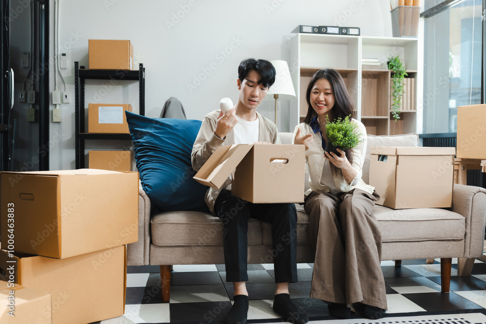 Young couple relaxing sitting on the sofa using the computer laptop around cardboard boxes, very happy moving to a new house. Young couple relaxing sitting on the sofa using the computer laptop around cardboard boxes, very happy moving to a new house.