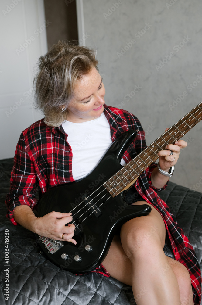 Fototapeta premium Mature Woman Playing Electric Guitar in Casual Attire