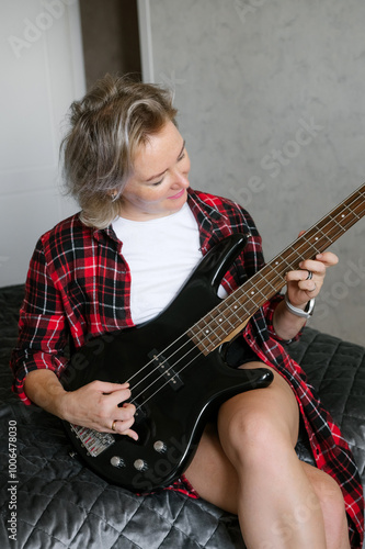 Mature Woman Playing Electric Guitar in Casual Attire