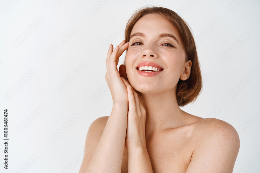 Skin care beauty. Smiling natural woman with naked shoulders and healthy clean and fresh skin, looking happy, touching cheek. Girl apply facial cosmetics, white background Skin care beauty. Smiling natural woman with naked shoulders and healthy clean and fresh skin, looking happy, touching cheek. Girl apply facial cosmetics, white background