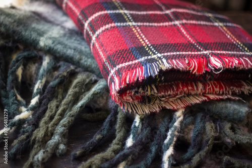 Stack of folded knitted wool scarf, Season of warm knitwear red, green, wood.