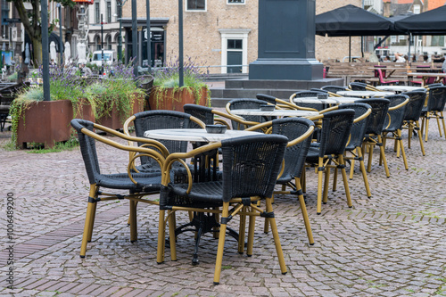 Empty outdoor cafe tables and chairs in urban setting. photo